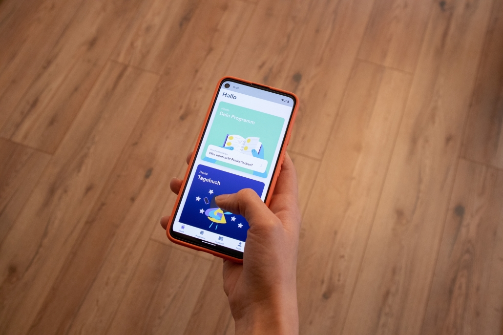 Hand mit Handy auf der App geöffnet ist