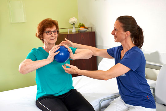 Physiotherapeutin mit Patientin und Ball