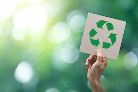 Hand hält Schild mit Recyclingschleife