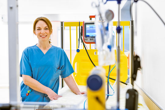 Pflegerin am leeren Kinderkrankenbett Pflegerin am leeren Kinderkrankenbett