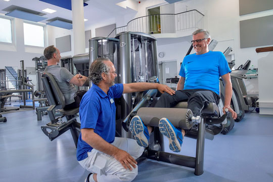 Physiotherapeut mit Patient an KG Gerät Physiotherapeut mit Patient an KG Gerät